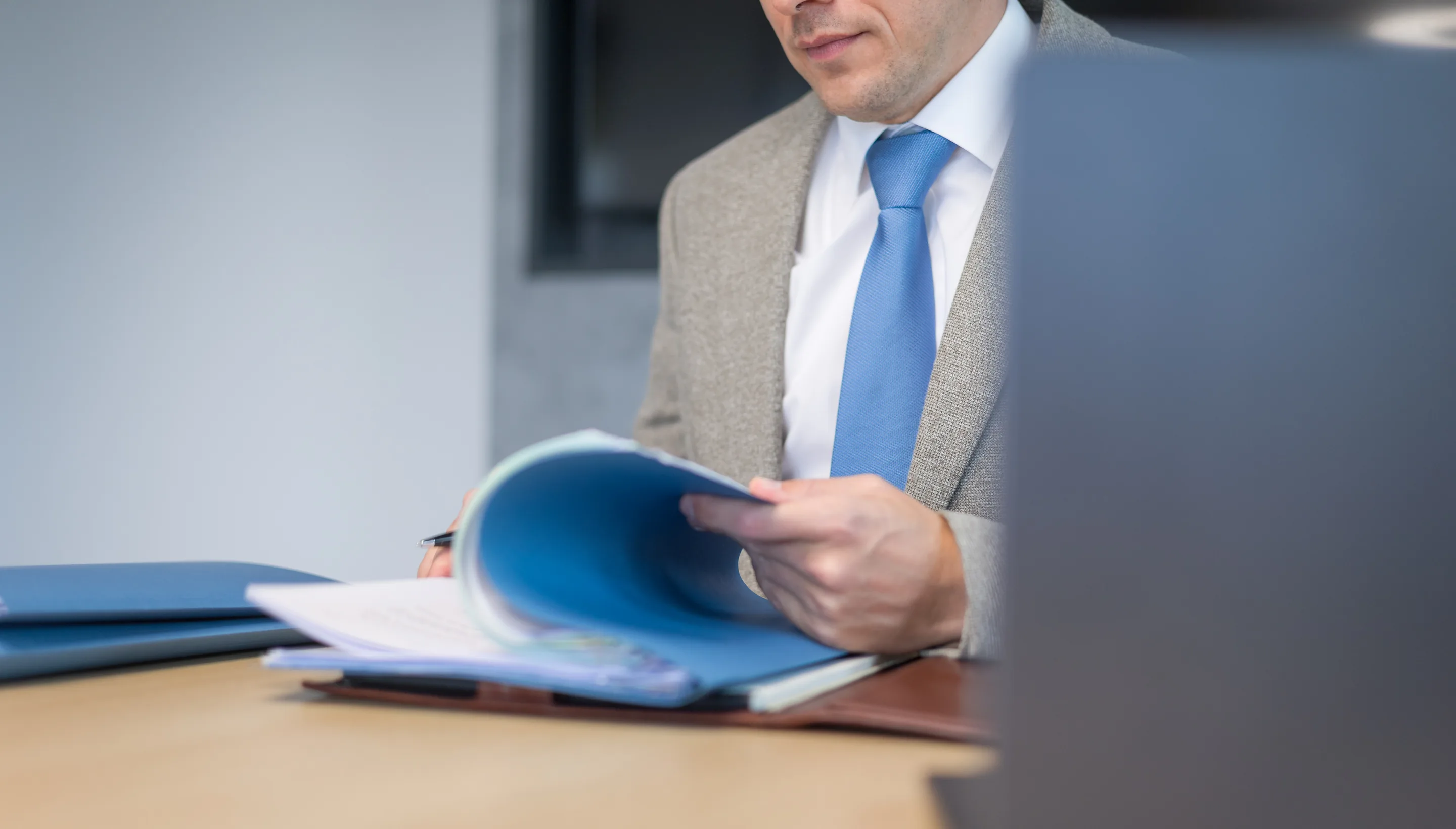 Dr. Daniel Holzinger schlägt eine Dokumentenmappe auf
